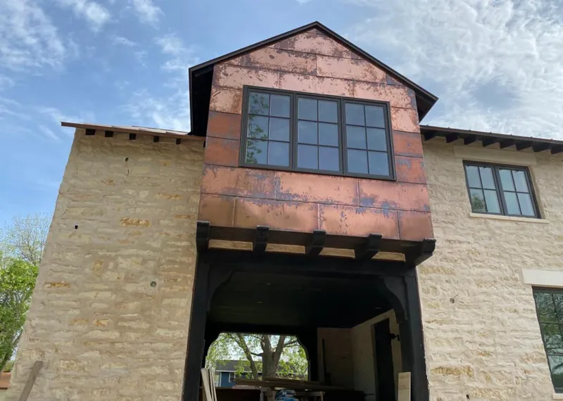 Copper metal panel facade on a stone building for Skylight Installation in Kirkwood